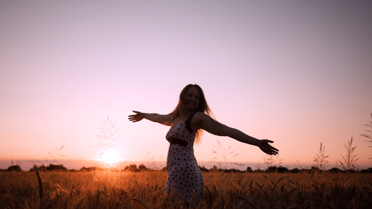 Woman in field with her arms open.