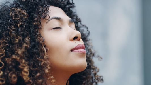 A serene woman with closed eyes, appearing relaxed and calm, symbolizing stress relief and improved sleep.