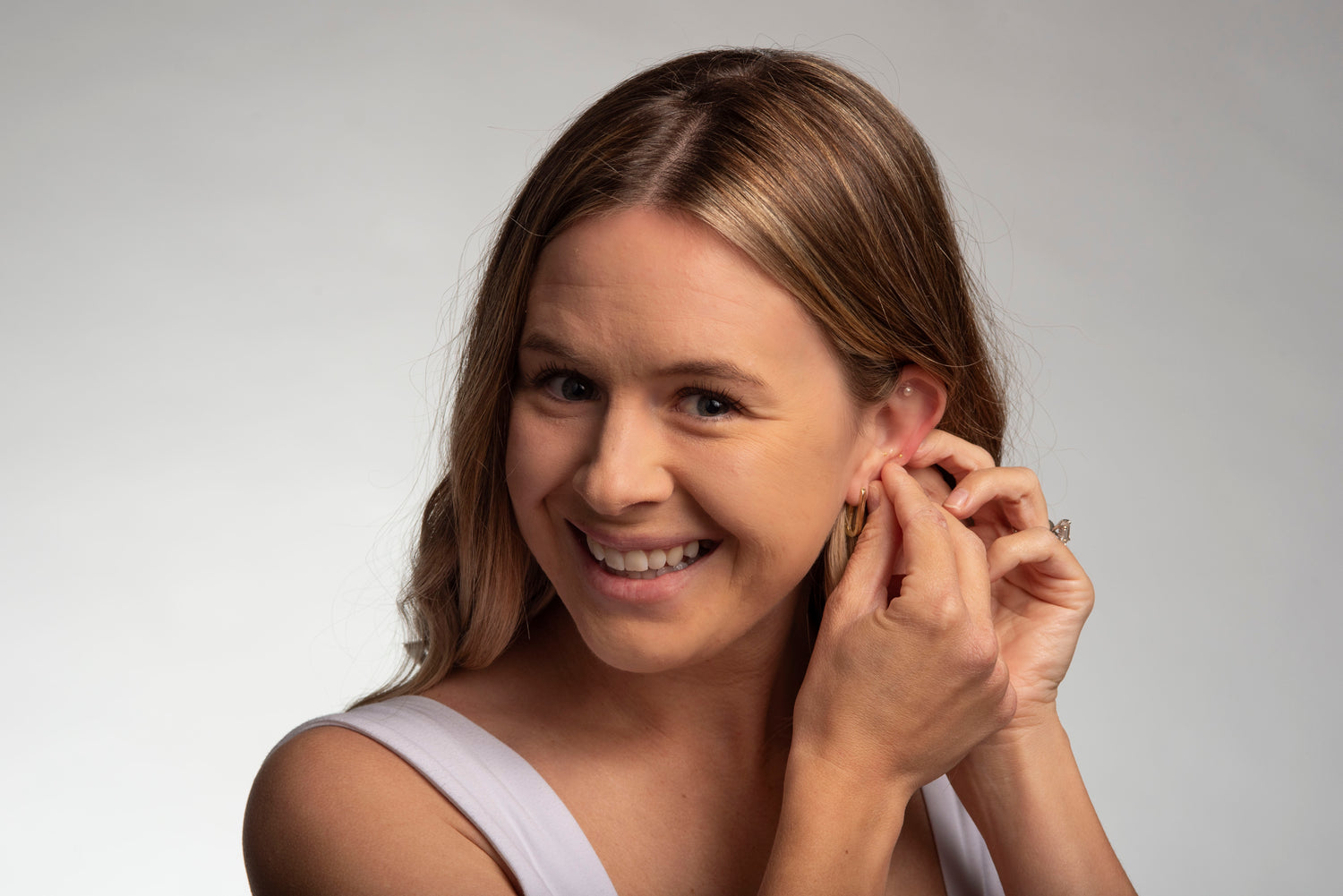 Girl massaging acupressure ear seeds to enhance them.