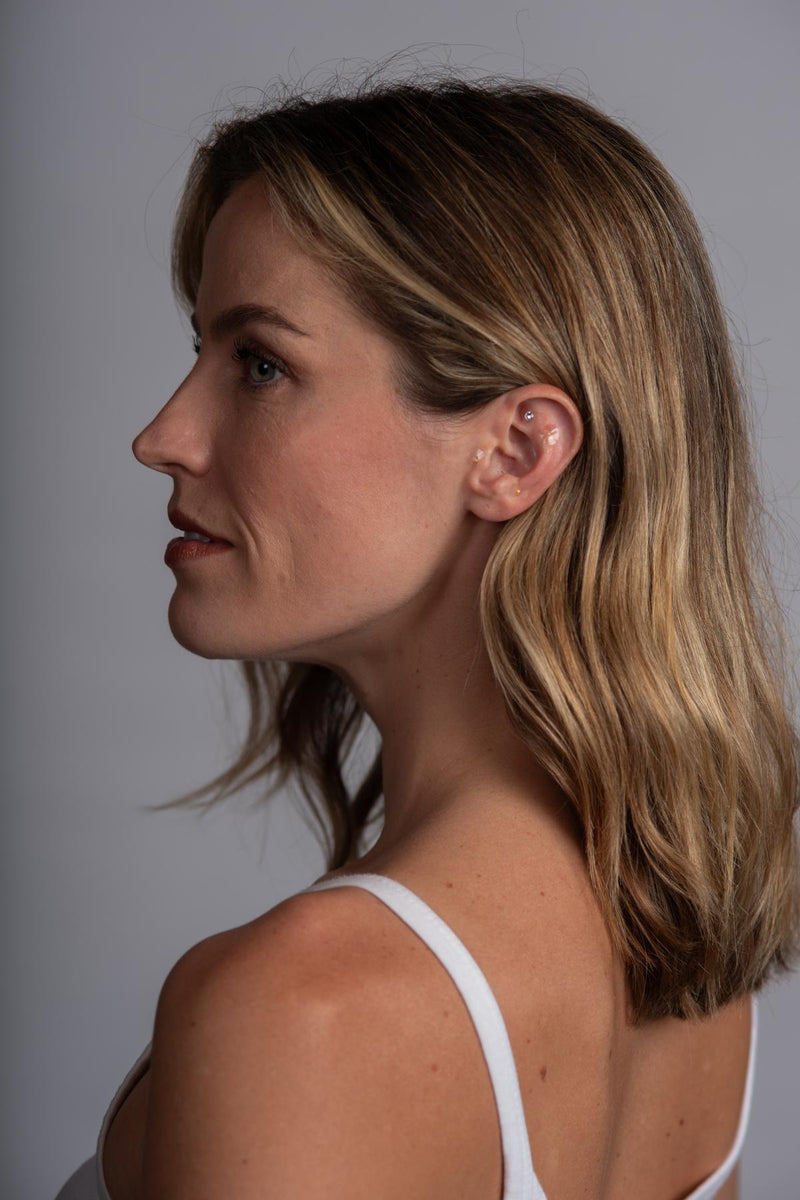 Woman's profile wearing ear seeds.